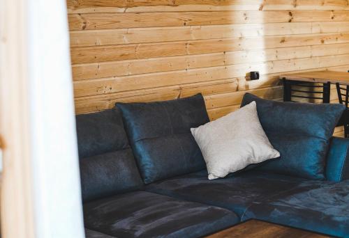 a blue couch with a white pillow on it at Misty Rocks Kazbegi in Stepantsminda