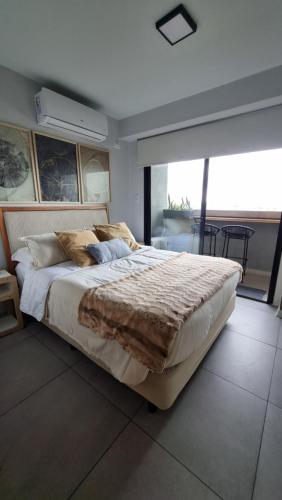 a bedroom with a large bed and a large window at Studio ideal viaje en pareja o trabajo in San Miguel de Tucumán