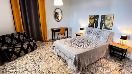 ein Schlafzimmer mit einem Bett, einem Stuhl und einem Spiegel in der Unterkunft Finca Tylia, Olta, Calpe in Benissa