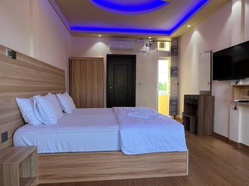 a bedroom with a large bed with a blue ceiling at Aasna Inn in Thulusdhoo