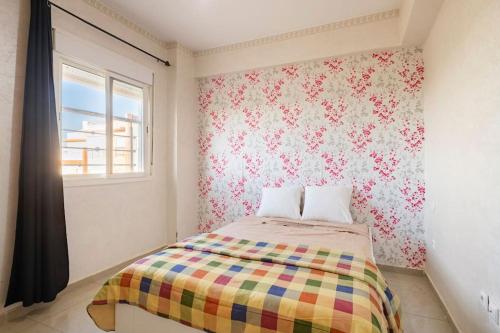 - une chambre avec un lit et une couverture colorée dans l'établissement Tanger plage Al Houara, à Tanger