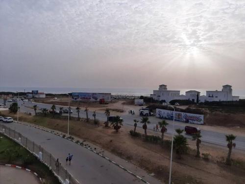 une rue avec des palmiers et des voitures sur une route dans l'établissement Tanger plage Al Houara, à Tanger