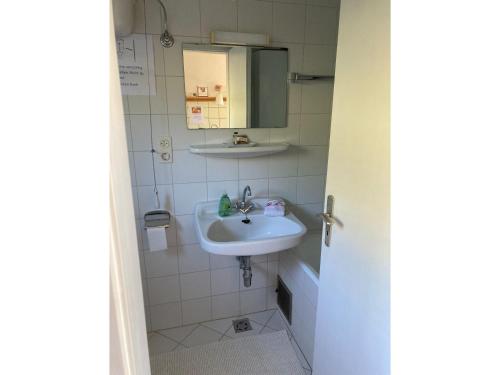 uma casa de banho com um lavatório e um espelho em Berghütterl - Ferienhaus Ingerlhof em Tegernsee