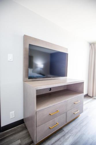 a flat screen tv sitting on top of a wooden entertainment center at La Quinta by Wyndham Dallas I-35 Walnut Hill Ln in Dallas