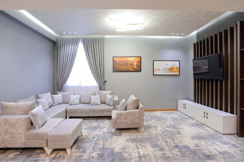 a living room with a couch and a tv at PREMIER HOTEL in Andijan