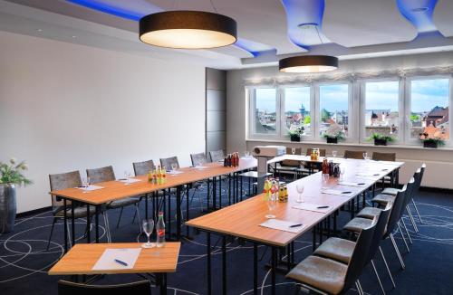a row of tables and chairs in a room with windows at Best Western Hotel Das Donners in Cuxhaven