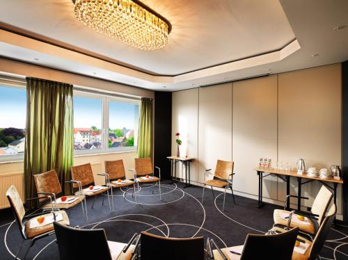 a conference room with chairs and tables and windows at Best Western Hotel Das Donners in Cuxhaven