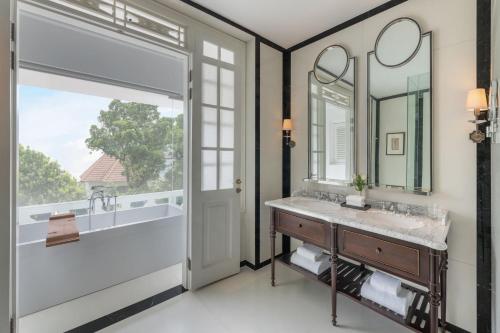 a bathroom with a sink and a mirror at The Hermitage, A Tribute Portfolio Hotel, Jakarta in Jakarta