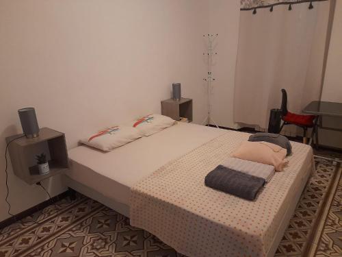 een slaapkamer met een groot bed met 2 luidsprekers bij Petit appart au cœur des REMPARTS - Netfix et connection fibre gratuits in Carpentras