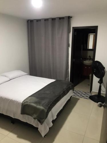 a bedroom with a bed and a bathroom with a sink at Apartamento cerca estacion de lagos in Floridablanca