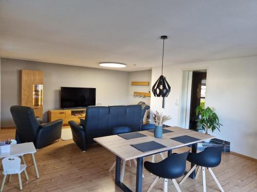 een woonkamer met een tafel en blauwe stoelen bij Ferienwohnung Hans im Glück in Olbernhau