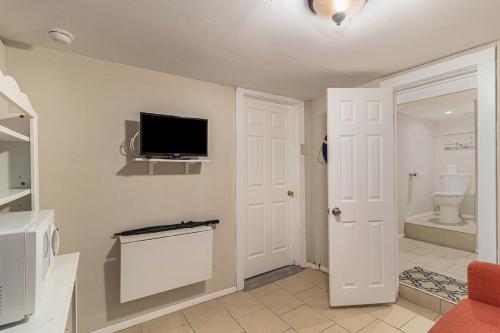 uma casa de banho com WC e uma televisão na parede em Paradise Perch em Galveston