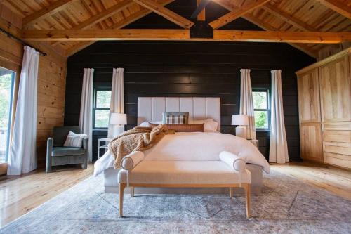Un dormitorio con una cama grande en una habitación con techos de madera. en The Ridge: A Modern Cabin en Bostic