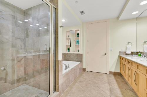 a bathroom with a shower and a tub and a sink at Sapphire Condominiums #806 in South Padre Island