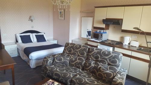 a hotel room with a bed and a couch and a kitchen at Devoncourt Short Term Rentals in Exmouth