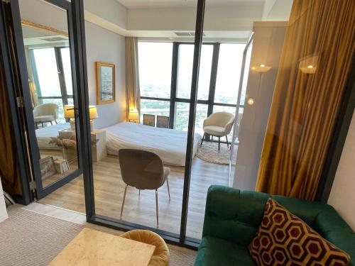 ein Hotelzimmer mit einem Bett und Blick auf einen Balkon in der Unterkunft Parisian style apartment at The Smith Alam Sutera in Tangerang