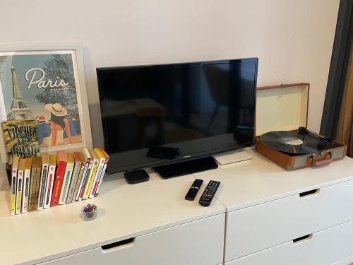 a tv sitting on top of a dresser at Parisian style apartment at The Smith Alam Sutera in Tangerang