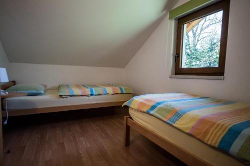2 camas en una habitación pequeña con ventana en Hiša Nataša, en Drežnica