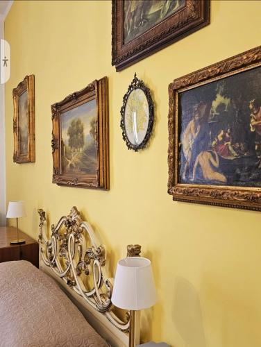 um quarto com uma cama e pinturas na parede em CAROLINA'S APARTMENT em Caserta