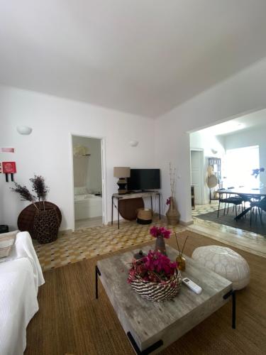 a living room with a table with flowers on it at Casa Monte Tamissa in Vila Real de Santo António