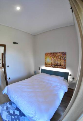 a bedroom with a white bed in a room at Lake Plastira Lodge in Kalyvia