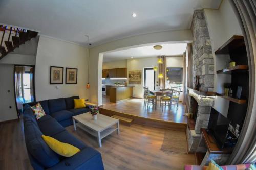 sala de estar con sofá azul y mesa en Lake Plastira Lodge, en Kalyvia