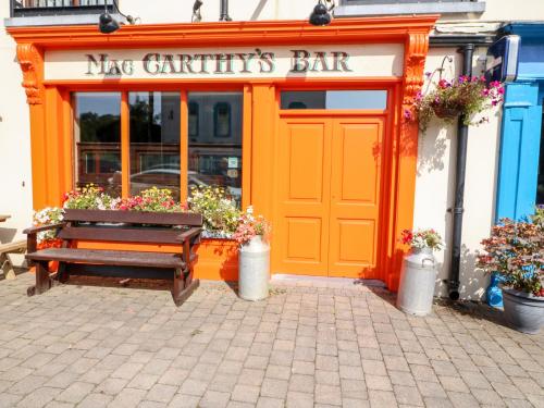 an orange restaurant with a bench in front of it at 2 Garnish Court in Glengarriff