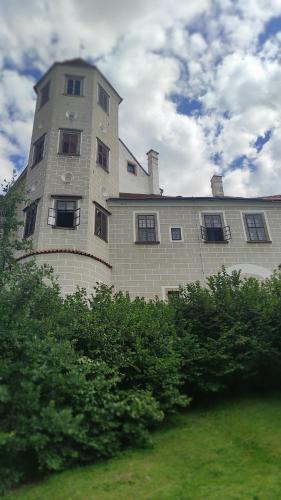 a large building with a tower on the side of it at Apartment Telč Hradecka in Telč