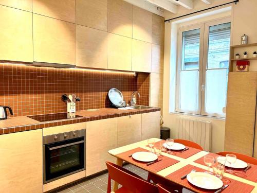 a kitchen with a table and chairs in a kitchen at Magnifique maison de courée renovée - Lille centre in Lille