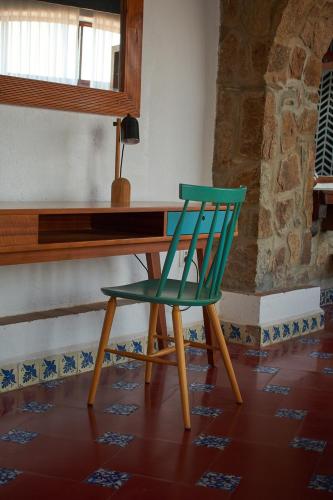 a green chair sitting in front of a wooden desk at Casa Lisa in Acapulco