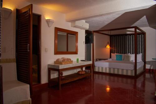 a room with a bedroom with a bed and a mirror at Casa Lisa in Acapulco