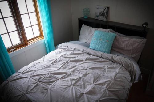 Stratford的住宿－Chalet Le Shack O2，一张白色的床,上面有蓝色的枕头