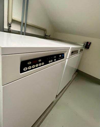 a white dishwasher in a kitchen with a wall at Seefeld Residenz in Zürich