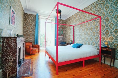 een slaapkamer met een rood hemelbed en een open haard bij Estacart - Grenoble Centre in Grenoble
