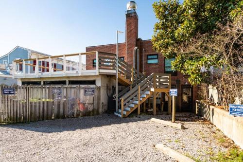 a house with a staircase in front of a fence at Why Knot Getaway...Rooftop with WaterView! Unit D in Beaufort