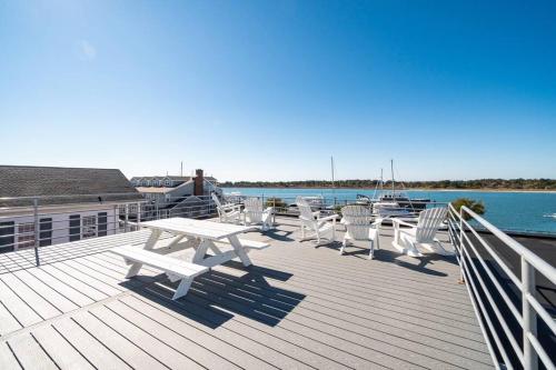 a deck with a picnic table and chairs on the water at Why Knot Getaway...Rooftop with WaterView! Unit D in Beaufort
