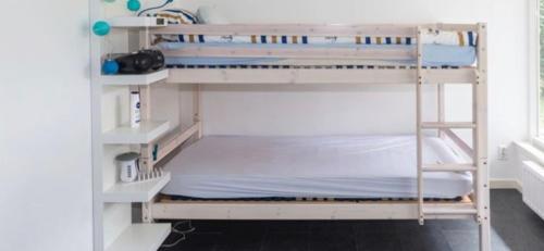 a room with two bunk beds in a room at Bungalow near beach with large private garden - not for companies in Ouddorp