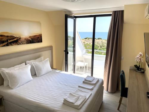 een slaapkamer met een bed en uitzicht op de oceaan bij Sea View Apartment free parking in Primorsko