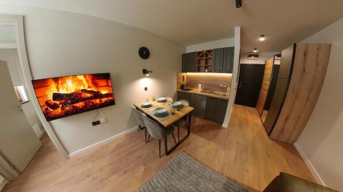 a living room with a table and a fireplace at Bela Reka C320 Kopaonik Brzece in Brzeće
