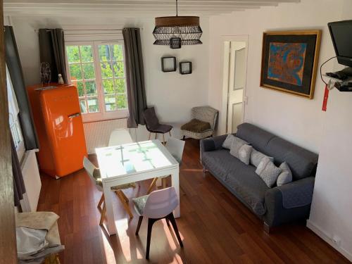 a living room with a couch and a table at GÎTE VIGNERAIE in Sainte-Gemme-Moronval