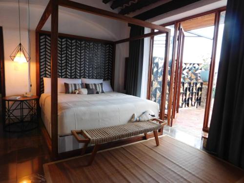 a bedroom with a bed and a bench in a room at Casa Lisa in Acapulco