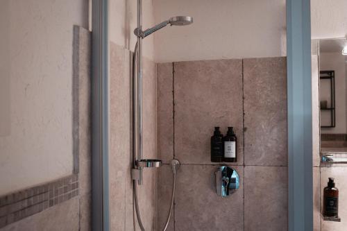 La salle de bains est pourvue d'une douche et de bouteilles murales. dans l'établissement Suite Dreams Studio, à Brême