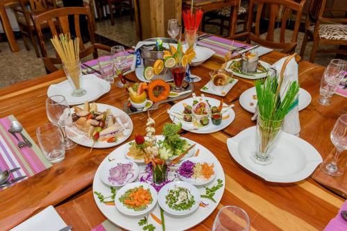 a wooden table with plates of food on it at The Glacier Hotel Nanyuki in Nanyuki