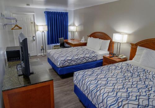 Habitación de hotel con 2 camas y TV de pantalla plana. en America's Best Value Inn Lancaster, en Lancaster