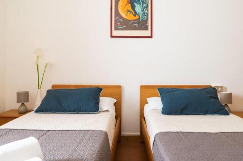 two beds sitting next to each other in a room at Hotel L'Aragosta in La Caletta