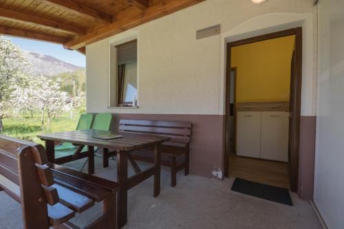 Zimmer mit einem Tisch, Stühlen und einer Tür in der Unterkunft Apartment and Room Natasa in Kobarid