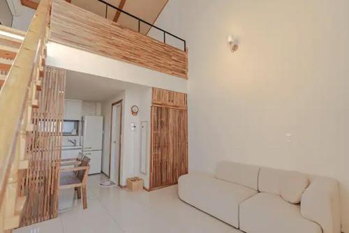 a living room with a white couch and a staircase at Le Village Aewol F in Jeju