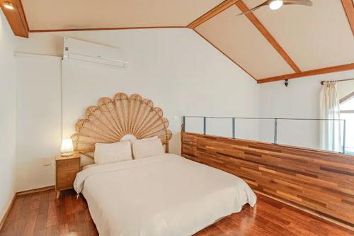 a bedroom with a large bed with a wooden headboard at Le Village Aewol F in Jeju