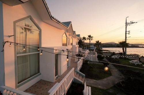 a house with a string of lights on the balcony at Le Village Aewol F in Jeju