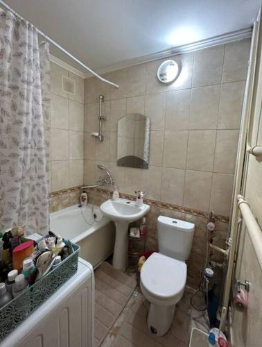 een badkamer met een toilet, een wastafel en een bad bij Weendrush Apartment 21 
